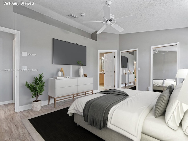 bedroom featuring light wood-type flooring, a textured ceiling, and ceiling fan