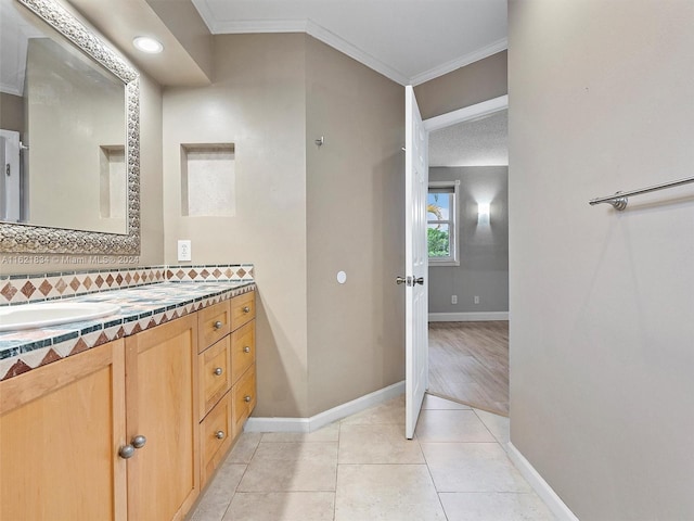 bathroom featuring ornamental molding, vanity, a textured ceiling, and tile patterned floors