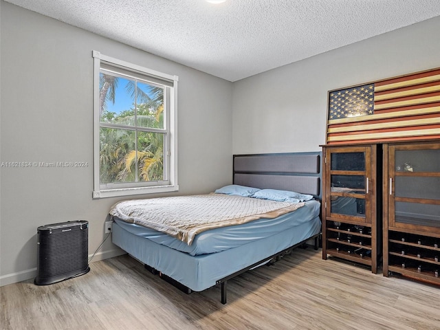 bedroom with a textured ceiling and hardwood / wood-style flooring