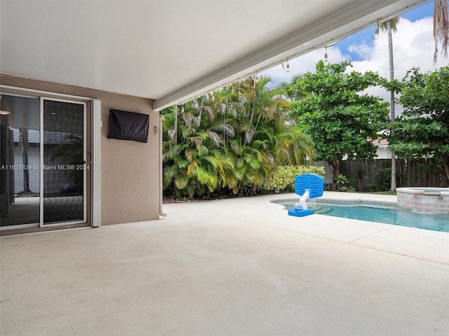 view of swimming pool featuring a patio and an in ground hot tub