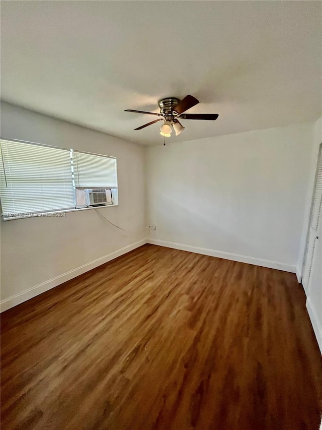 unfurnished room with cooling unit, dark wood-type flooring, and ceiling fan