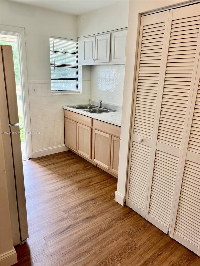 kitchen featuring a wealth of natural light, white fridge, sink, and light brown cabinets