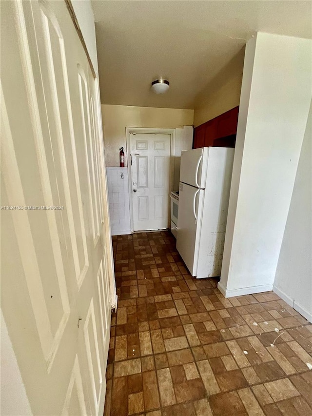 hall featuring dark tile patterned flooring