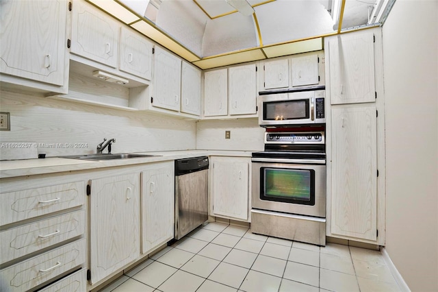 kitchen featuring sink, light tile patterned floors, and stainless steel appliances