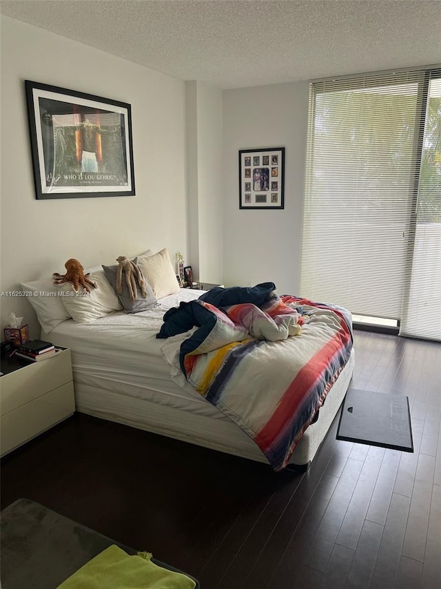 bedroom with a textured ceiling and wood-type flooring