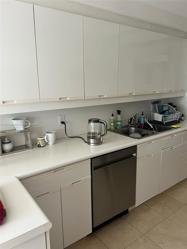 kitchen featuring white cabinets, dishwasher, light tile patterned flooring, and sink