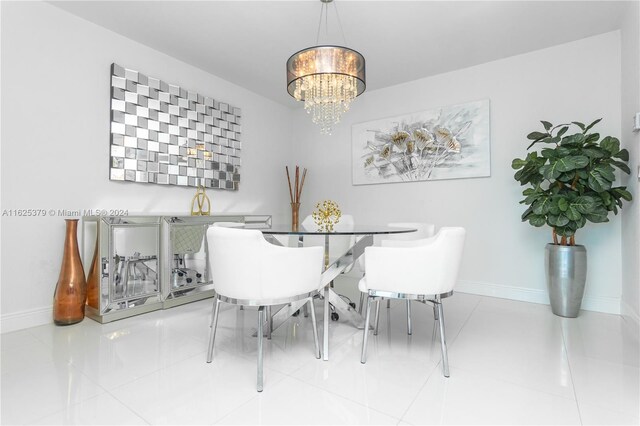 tiled dining room with an inviting chandelier