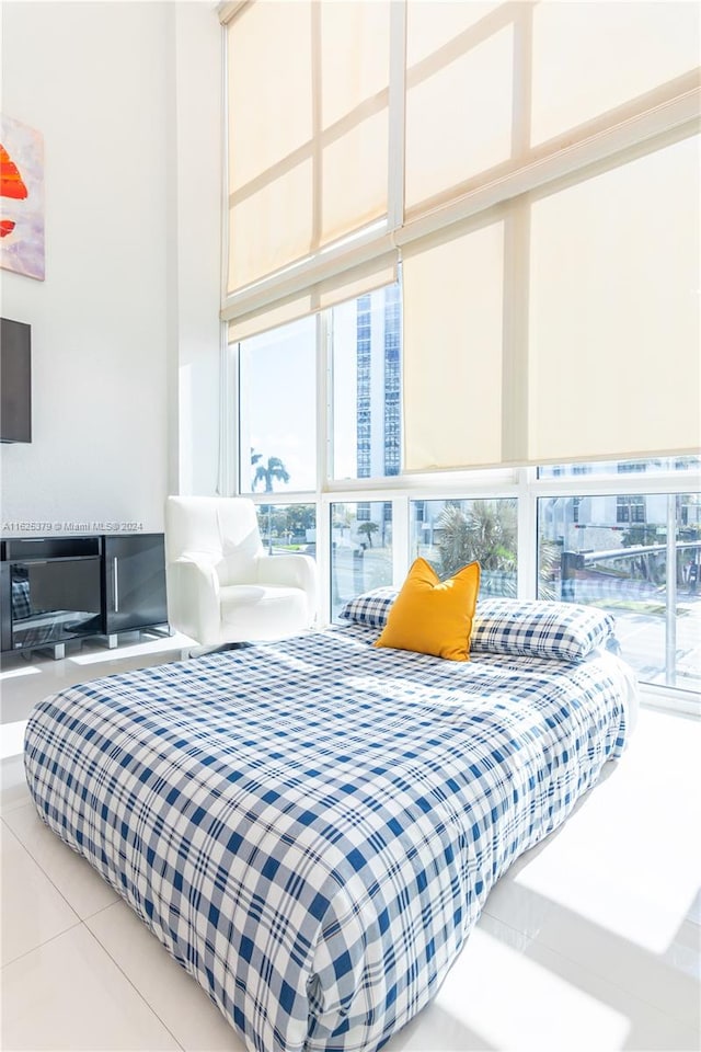 bedroom featuring expansive windows and light tile patterned floors