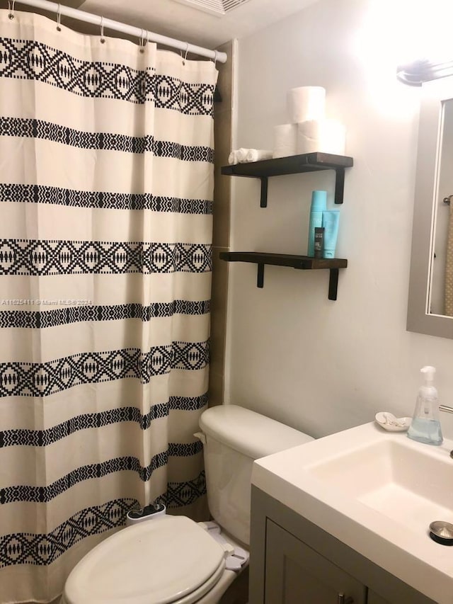 bathroom with a shower with curtain, vanity, and toilet