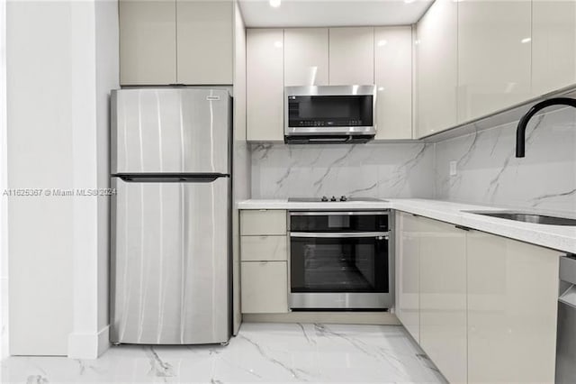 kitchen featuring sink, light tile patterned flooring, decorative backsplash, and stainless steel appliances