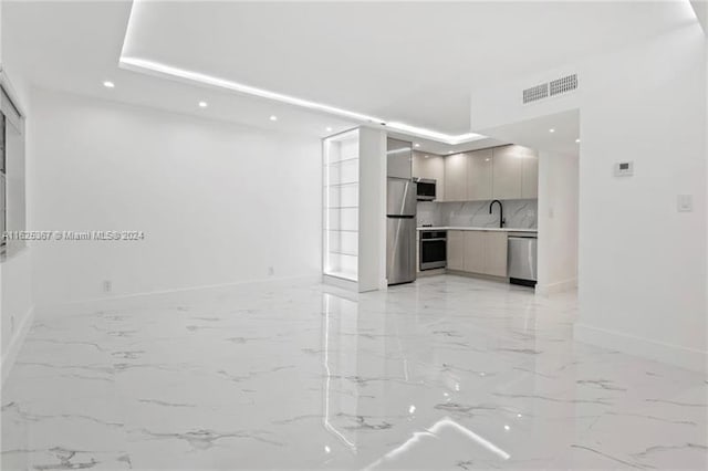 unfurnished living room with sink and light tile patterned floors