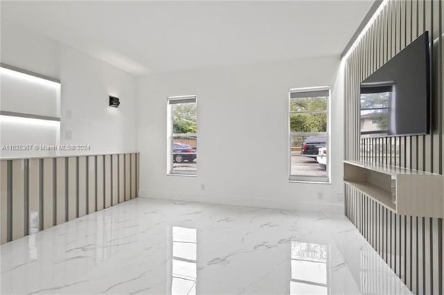 spare room featuring a wealth of natural light and light tile patterned floors