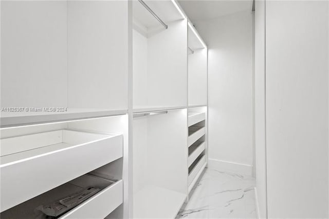 walk in closet with light tile patterned floors