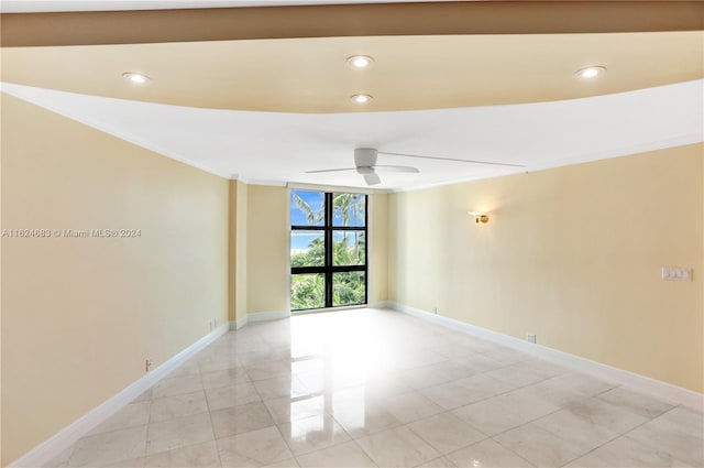 spare room featuring expansive windows, light tile patterned floors, ceiling fan, and crown molding