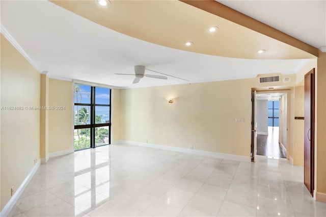 spare room with crown molding, expansive windows, light tile patterned floors, and ceiling fan