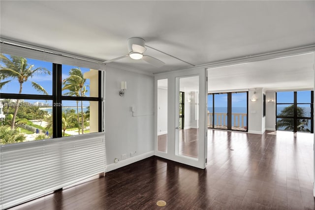 unfurnished room with hardwood / wood-style flooring, a healthy amount of sunlight, floor to ceiling windows, and ceiling fan