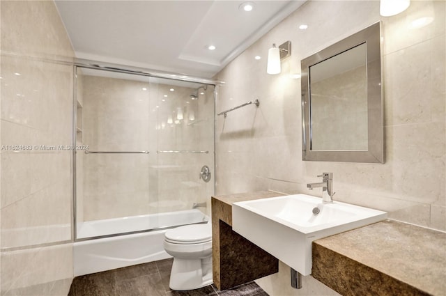 full bathroom with tile patterned flooring, tile walls, toilet, and enclosed tub / shower combo