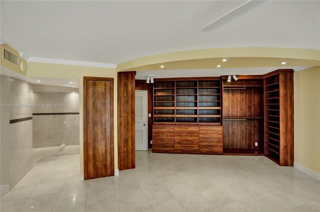 interior space featuring light tile patterned floors and crown molding