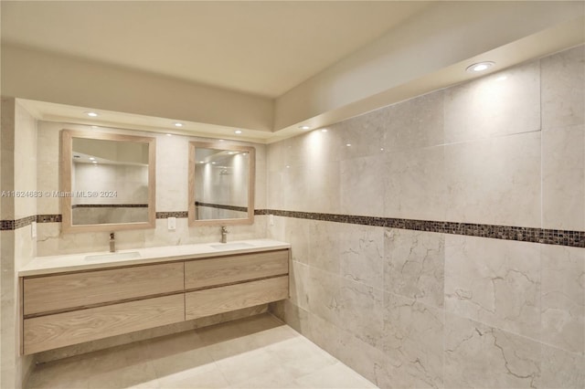 bathroom with tile walls, tasteful backsplash, dual bowl vanity, and tile patterned flooring