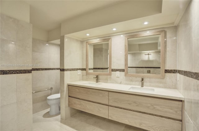 bathroom featuring dual vanity, tile patterned floors, tile walls, and toilet