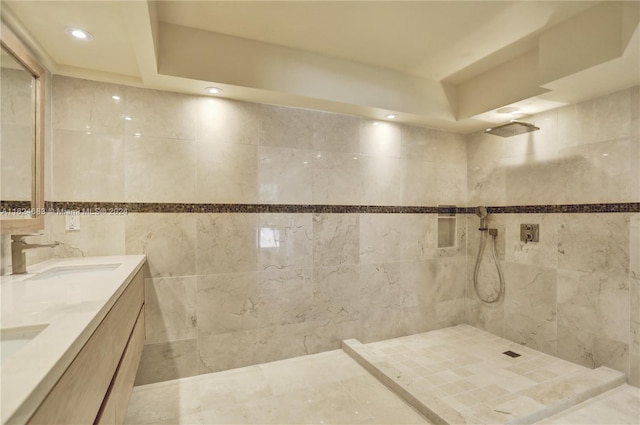 bathroom with tile patterned flooring, tile walls, dual vanity, and tiled shower