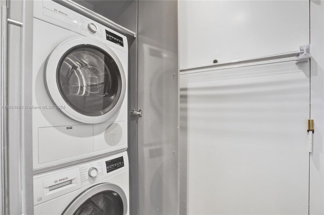 washroom featuring stacked washer / drying machine