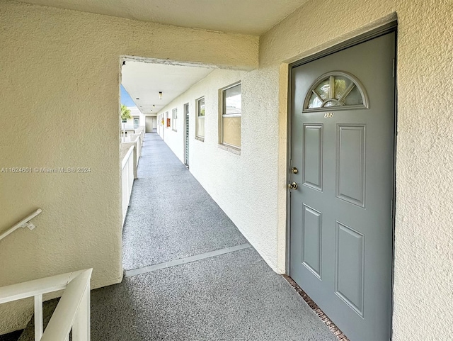 doorway to property featuring a balcony and stucco siding