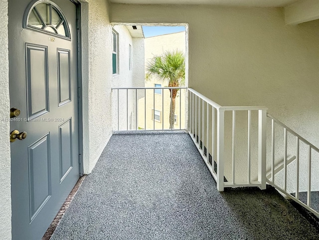 entrance to property with a balcony and stucco siding