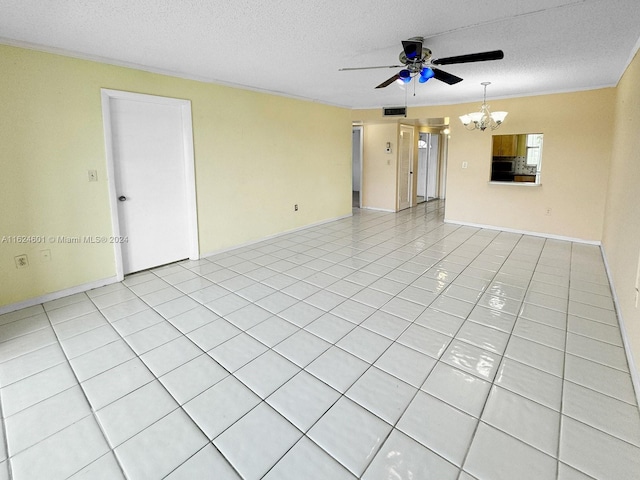 empty room featuring light tile patterned floors, a textured ceiling, ceiling fan with notable chandelier, and visible vents