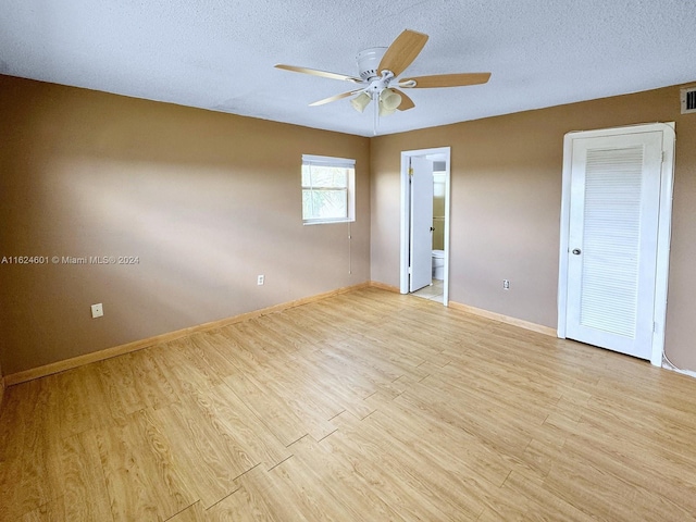 unfurnished bedroom with a textured ceiling, light wood finished floors, a ceiling fan, and baseboards