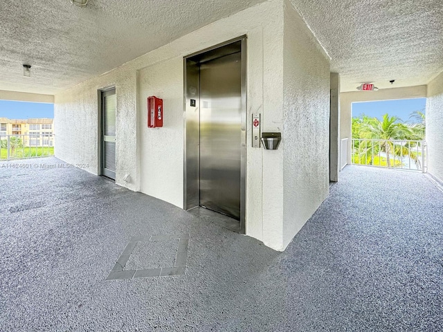 garage with elevator and a textured wall