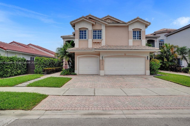 mediterranean / spanish house with stucco siding, a tile roof, decorative driveway, and a garage