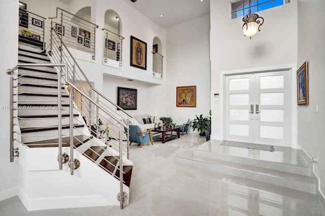 tiled entryway featuring french doors and a high ceiling