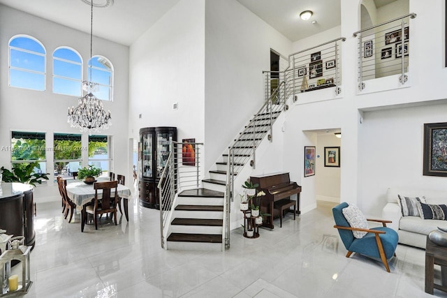 foyer with light tile patterned flooring, a chandelier, and a high ceiling