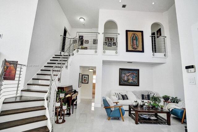 living room featuring light tile patterned floors and a high ceiling