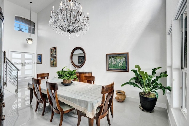 dining space with an inviting chandelier, tile patterned floors, french doors, and a high ceiling