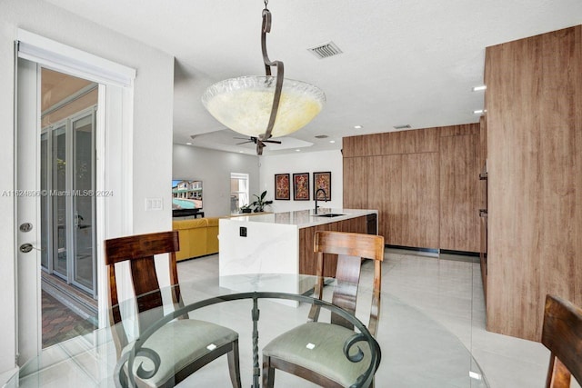 dining room with sink, a textured ceiling, ceiling fan, and light tile patterned floors