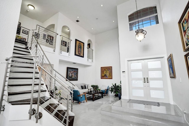 tiled entryway with plenty of natural light, french doors, and a towering ceiling