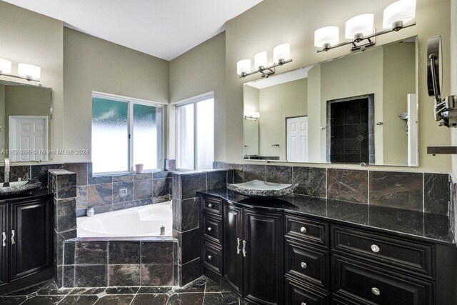 bathroom with vanity and a relaxing tiled tub