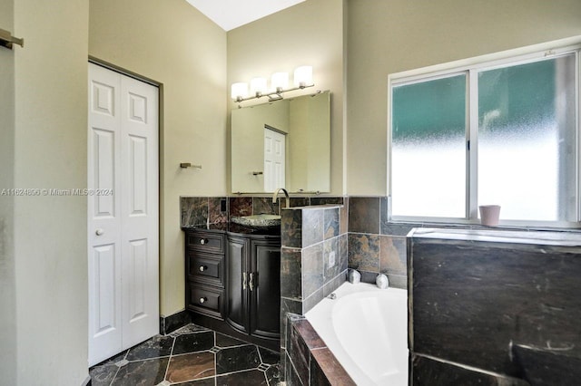 bathroom with vanity, tiled bath, and tile patterned floors