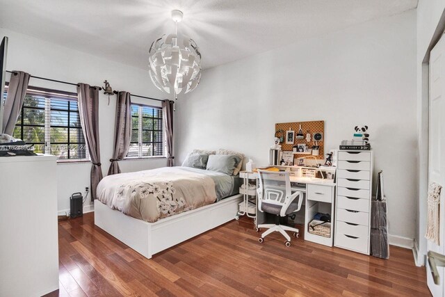 bedroom featuring dark wood-type flooring and a notable chandelier