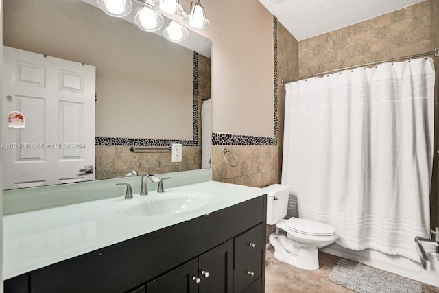 bathroom with tile patterned flooring, tile walls, toilet, and vanity