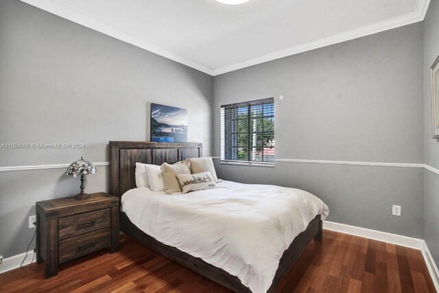 bedroom with crown molding and hardwood / wood-style flooring