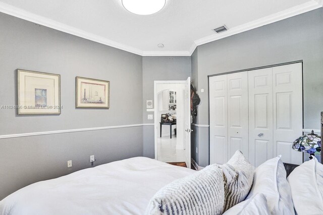 bedroom featuring crown molding and a closet