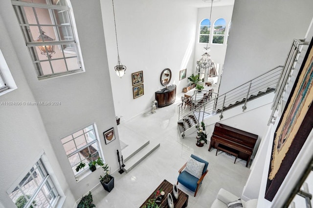 living room featuring a high ceiling, tile patterned flooring, and a notable chandelier