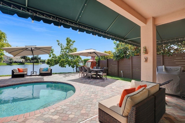 view of pool featuring a water view, a patio, and an outdoor hangout area