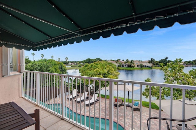 balcony featuring a water view and a fenced in pool