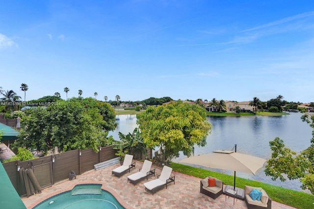 view of swimming pool featuring a patio area and a water view