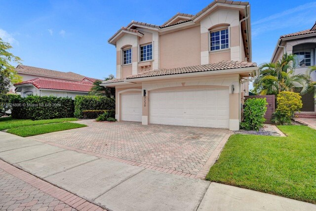 mediterranean / spanish-style house featuring a garage and a front yard