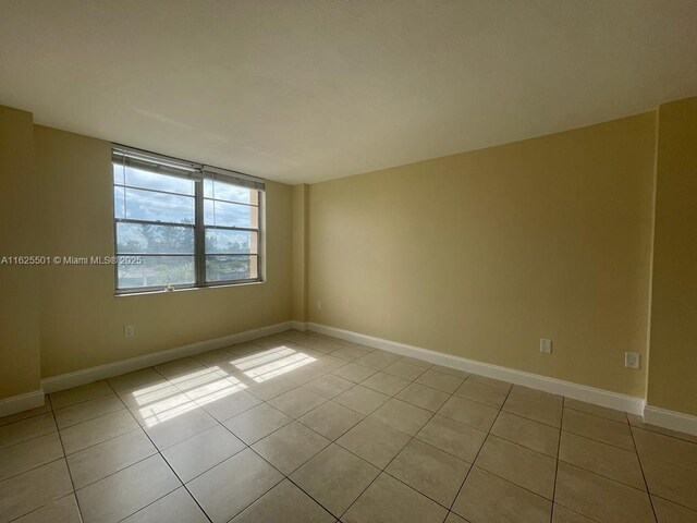 empty room featuring ceiling fan and tile patterned floors